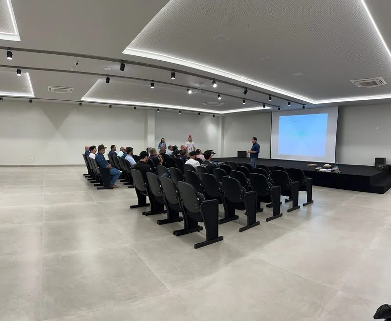 Auditório do Rosário Premium com o público sentado e o telão ligado ao fundo.