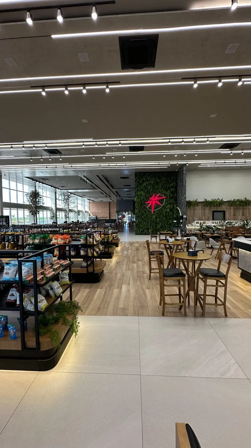Conveniência do Rosário Premium, com corredor amplo, mesas e a parede verde com a estrela.