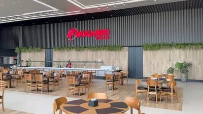 Salão do Restaurante Premium com as mesas de madeira vazias e o letreiro Rosário vermelho na parede escura.