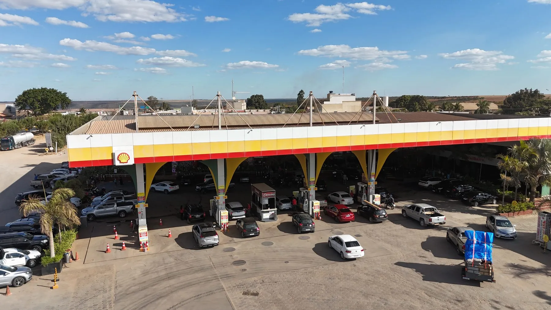 Cobertura em arcos do Posto Rosário, com carros na pista.