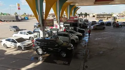 Carros abastecendo sob a cobertura amarela do Posto Rosário.