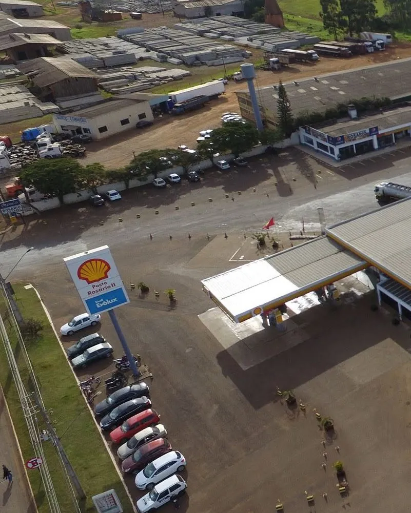 O Posto Rosário II visto do alto: o totem, a cobertura e o estacionamento de carros.