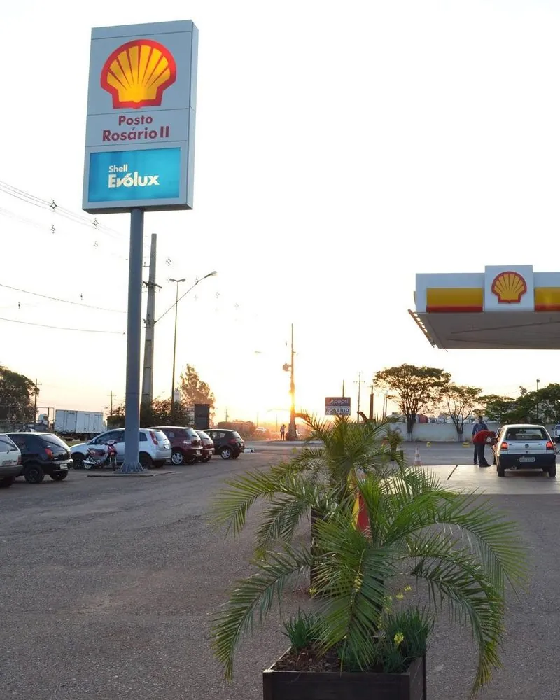 Totem Shell do Posto Rosário II, em Cascavel, no fim da tarde, com uma palmeira em vaso na frente.