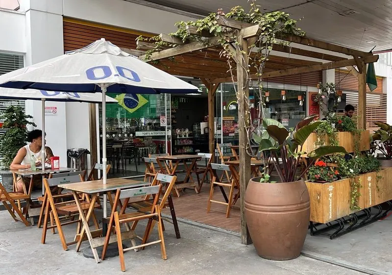 Mesas sob a pérgola ao lado da conveniência do Posto San Marino.