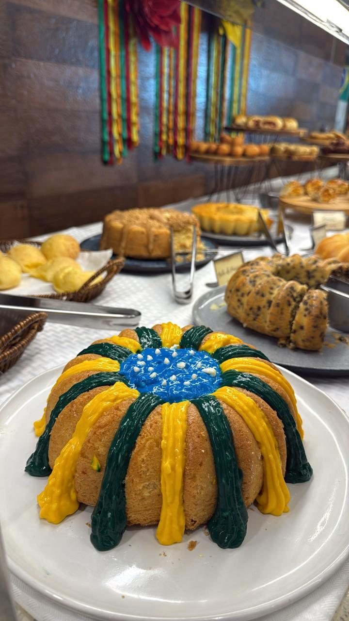 Bolo decorado em verde e amarelo na mesa de bolos do café