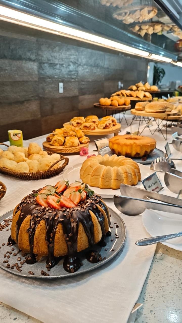 Mesa de bolos, folhados e pão de queijo no café da manhã