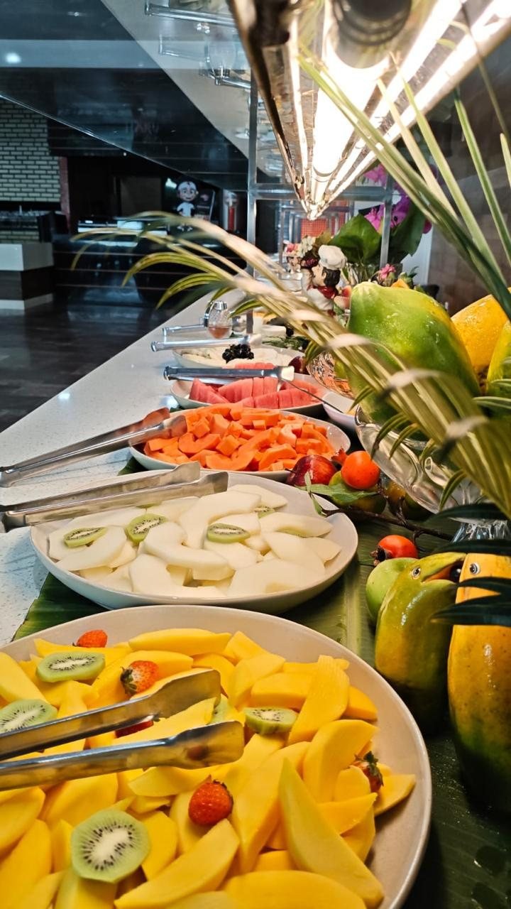 Fila de frutas do café da manhã: manga, mamão, melão e melancia