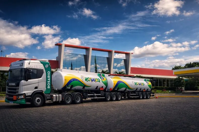 Carreta-tanque Rosário verde e amarela, com cavalo Scania, estacionada sob céu azul.