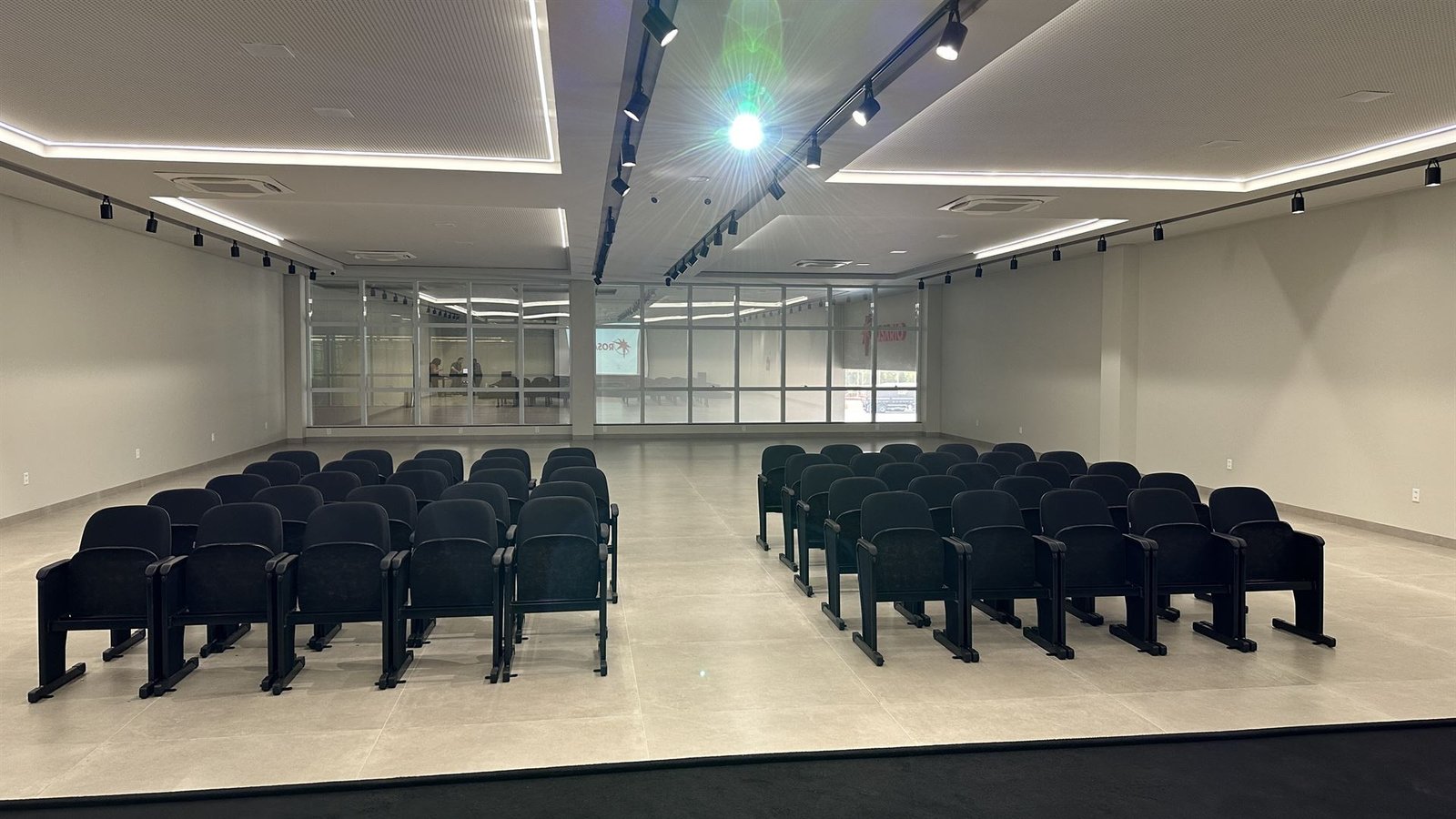 Auditório do Posto Premium: telão com a marca Rosário Premium e microfones sem fio